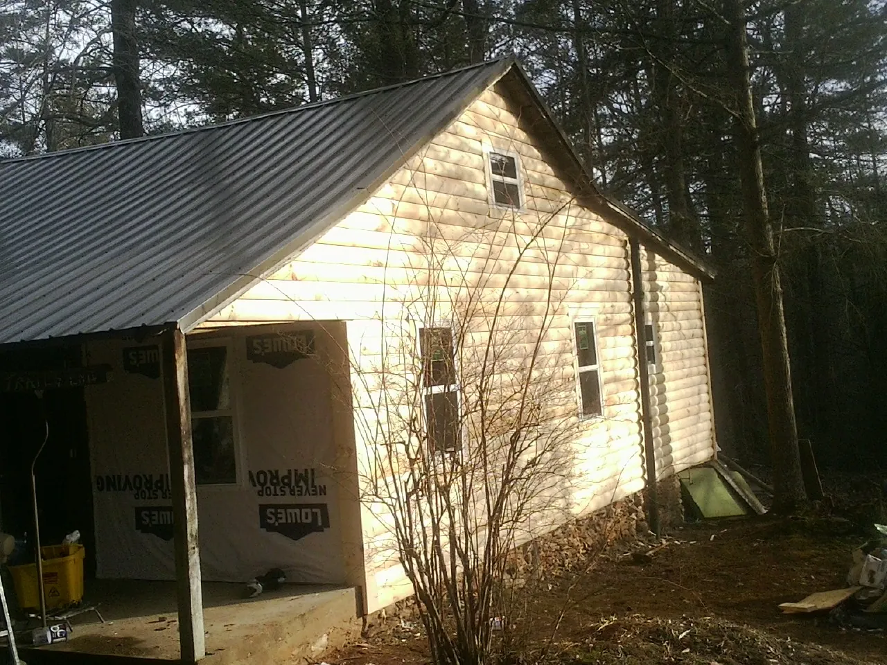 Log siding gable end under a dark metal roof edge in Cambridge